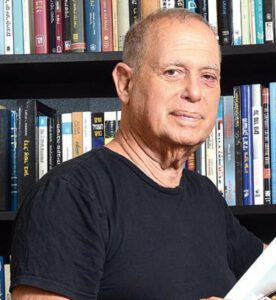 ד"ר דב ינאי על רקע ספרייה